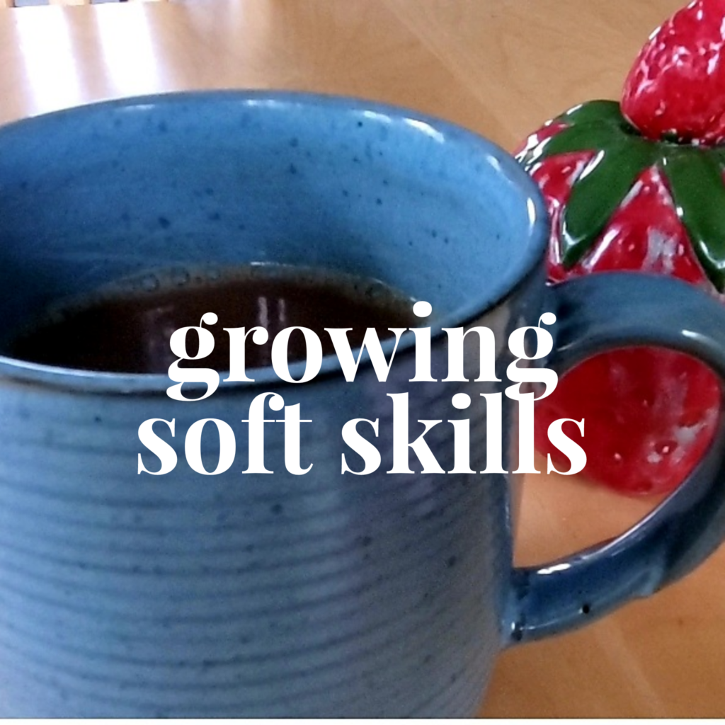 Blue coffee mug with "growing soft skills" in white across it